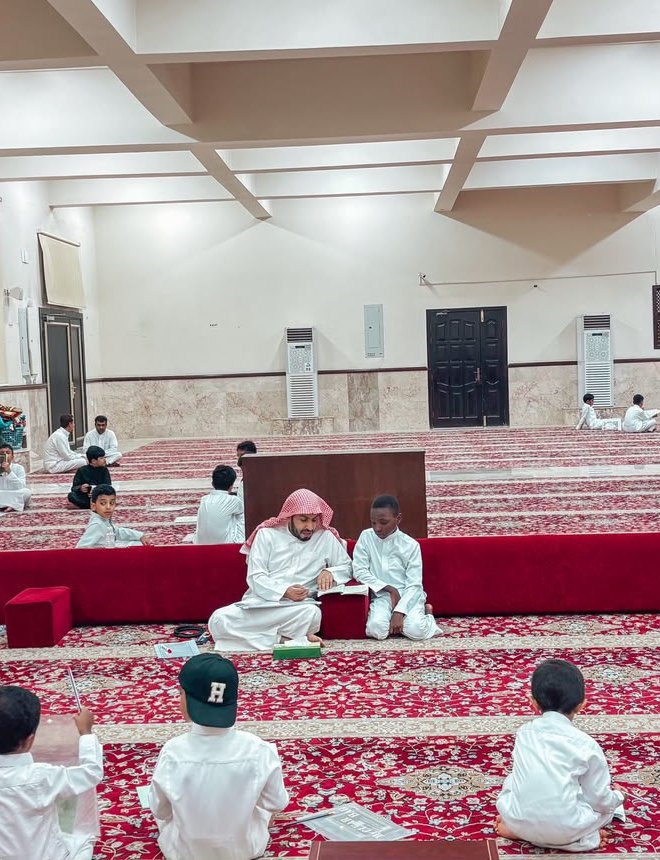 معلم يستمع إلى تلاوة طالب في مجمع ابن عثيمين
